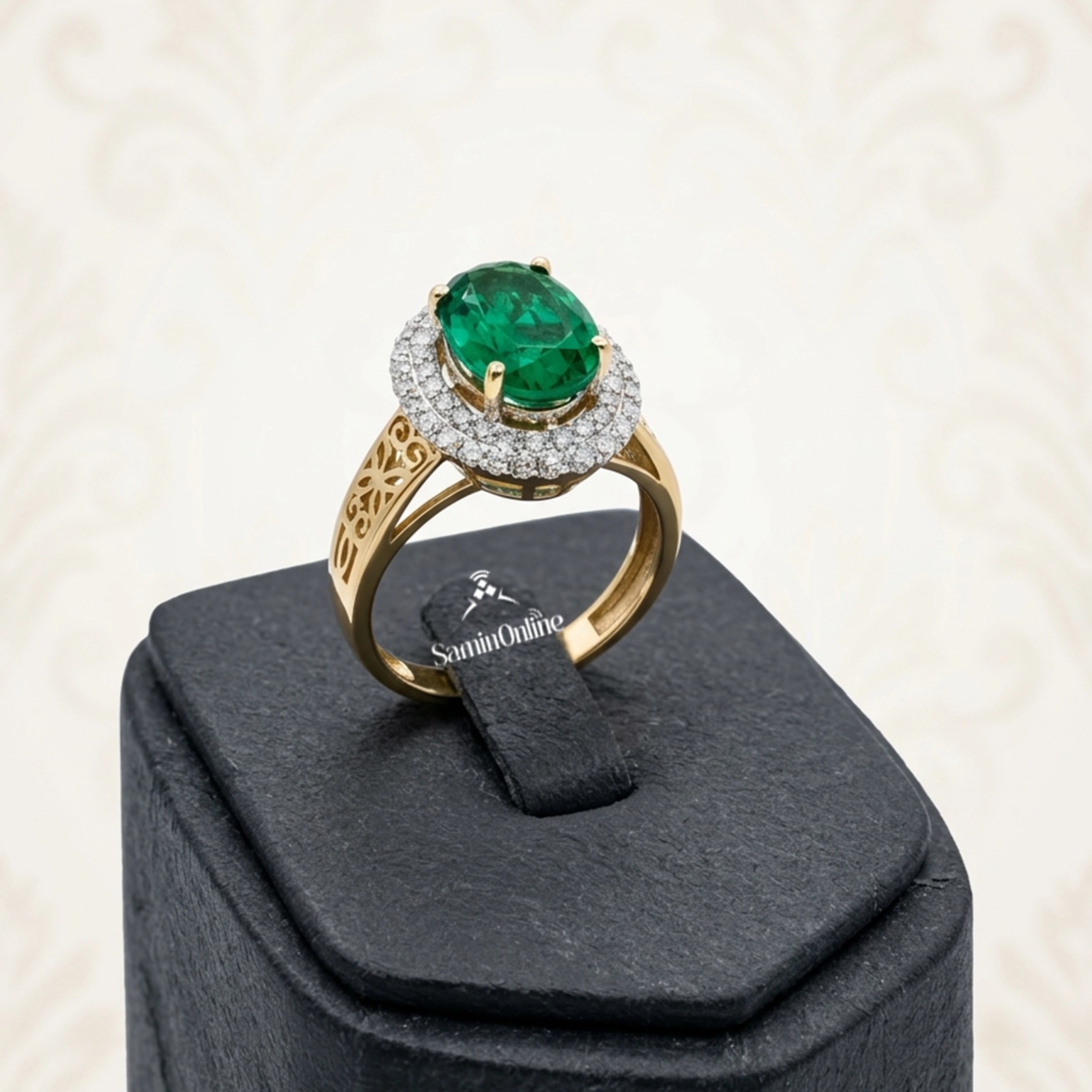 انگشتر طلای 18 عیار زرد مدل 6995 به وزن 4.97 گرم، دارای نگین زمرد بیضی‌تراش در مرکز و 52 قطعه برلیان سفید پاک به وزن 64 سوت در دو ردیف هالو و بدنه اسلیمی.